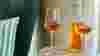 Bottle and two glasses of orange wine on small side table