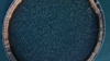 Overhead shot of an open ocean salmon farm with fish swimming in circles