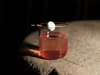 A cocktail in dramatic lighting on a stone table