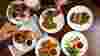 Overhead shot of people sharing small plates of food in a British pub