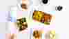 Overhead shot of salads, bread and drinks on white surface with napkin and cutlery