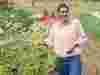 Geetie Singh Watson, owner of The Bull Inn in Totnes, standing in a field reaching out to tall flowers