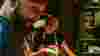 Chef Adriana Cavita in kitchen smiling at man blurred in foreground