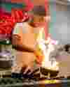 Chef cooking in pan with flames