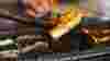 A close up shot of some skewered fish being cooked on a barbecue