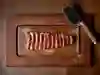 Overhead shot of a sliced steak on wooden board with a cleaver to the top right of the shot