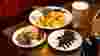 British pub food on wooden table: paté, fish and chips and chocolate cake, with pint of beer